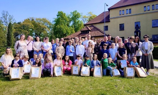 grupa osób na tle wyłuszczarni w Klosnowie