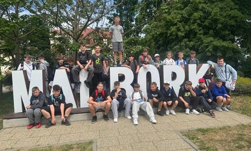 grupa uczniów przy napisie Malbork